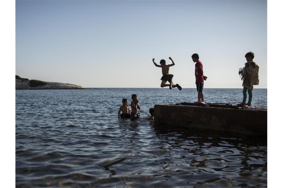 Kinder spielen am Meer neben ihrem Lagerplatz in der Nähe des ausgebrannten Flüchtlingslagers Moria. Foto: Socrates Baltagiannis/dpa