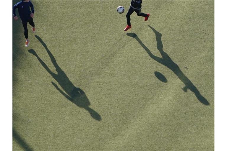 Kinder spielen auf einem Kunstrasenplatz Fußball. Foto: Marcus Brandt/dpa/Symbolbild