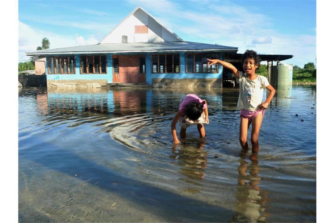 Weltweiter Massenprotest für eine bessere Klimapolitik Kinder spielen auf einem vom Meerwasser überfluteten Platz in Funafuti, der Hauptstadt des pazifischen Inselstaats Tuvalu. Foto: Kyodo/Archiv