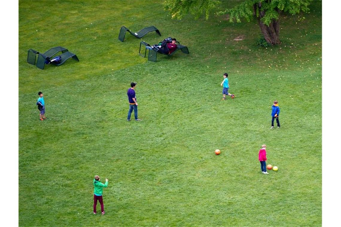 Kinder spielen auf einer Wiese im Höhenpark Killesberg in Stuttgart Fußball. Foto: picture alliance / dpa/Archivbild