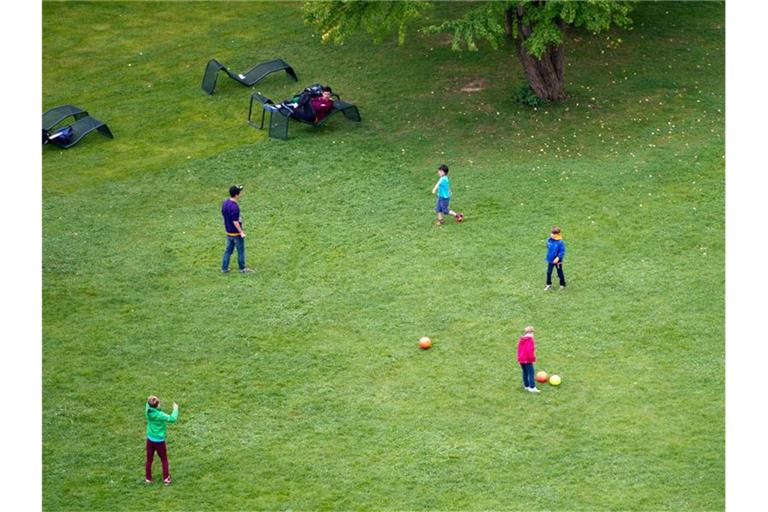 Kinder spielen auf einer Wiese im Höhenpark Killesberg in Stuttgart Fußball. Foto: picture alliance /dpa/Symbolbild
