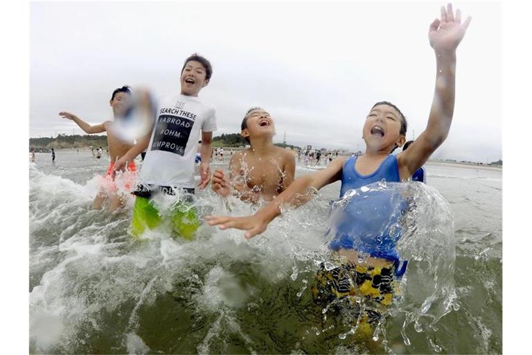 Kinder spielen im Wasser: Nach der Nuklearkatastrophe von Fukushima wurde der Strand zum ersten Mal wieder für Besucher zugelassen. Foto: kyodo