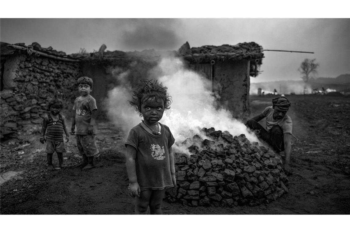 Kinder stehen in einem Kohlefeld von Jharia in Indien.