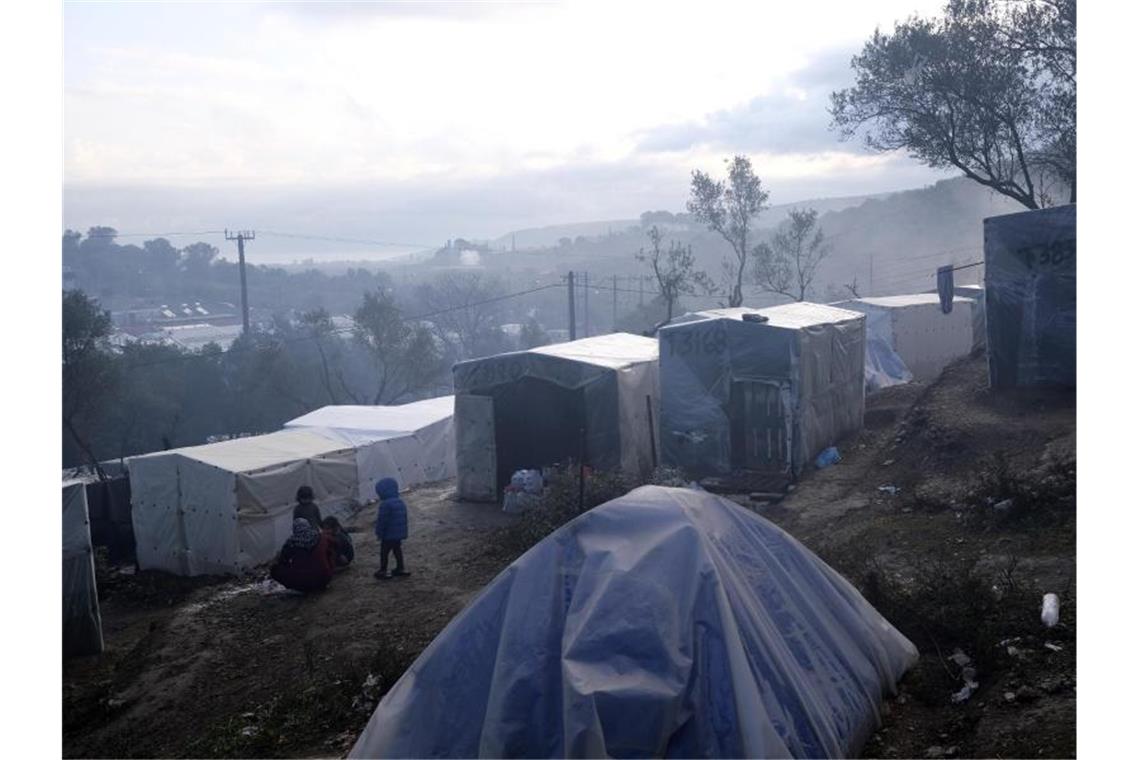 Kinder stehen nach einem Regenguss vor provisorisch errichteten Zelten außerhalb des Flüchtlingslagers Moria auf Lesbos. In und um die Registrierungslager harren mehr als 42.000 Menschen aus. Foto: Aggelos Barai/AP/dpa