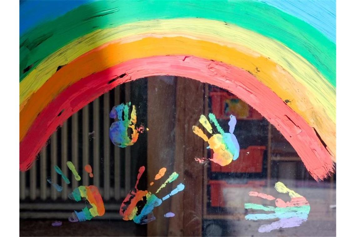 Kinderhände und ein Regenbogen sind an einer Kita zu sehen. Foto: Jens Kalaene/dpa-Zentralbild/dpa/Symbolbild