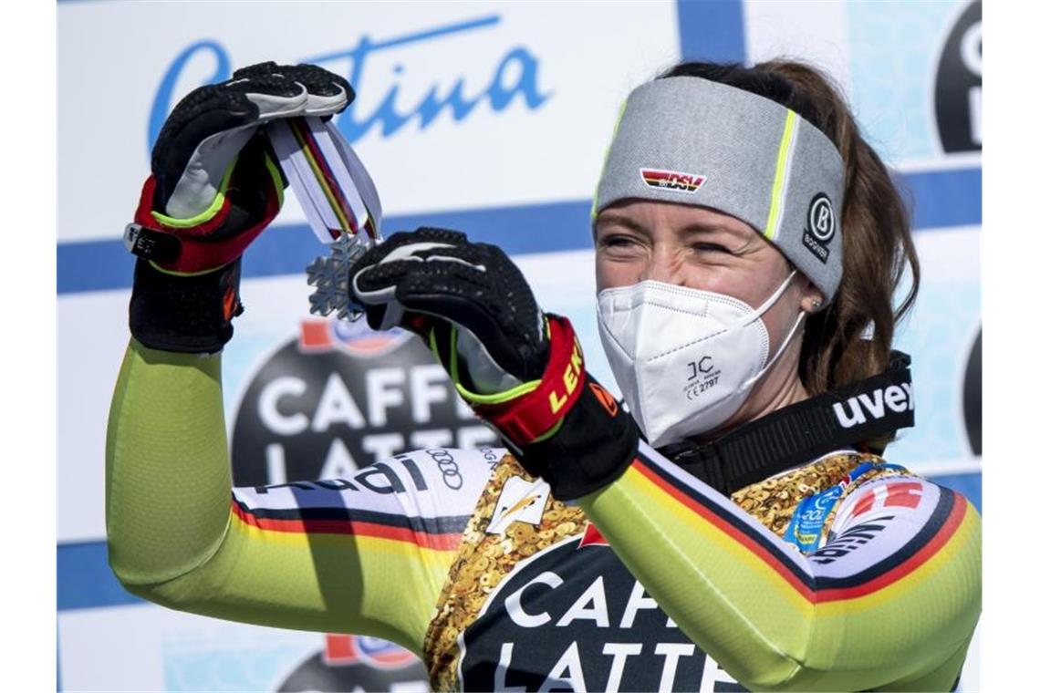 Kira Weidle hängt sich voller Freude die Silbermedaille bei der Siegerehrung selbst um den Hals. Foto: Jean-Christophe Bott/KEYSTONE/dpa