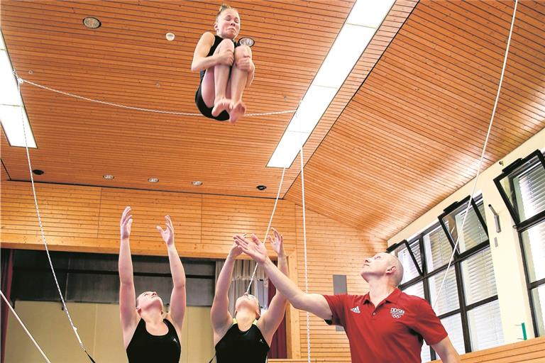 Kira Winter (links) und Lena Holdefer schleudern Lenia Hofmann für den Salto in die Höhe, Bundestrainer Igor Blintsov leistet bei seinem Besuch in Erbstetten Hilfestellung. Foto: A. Becher