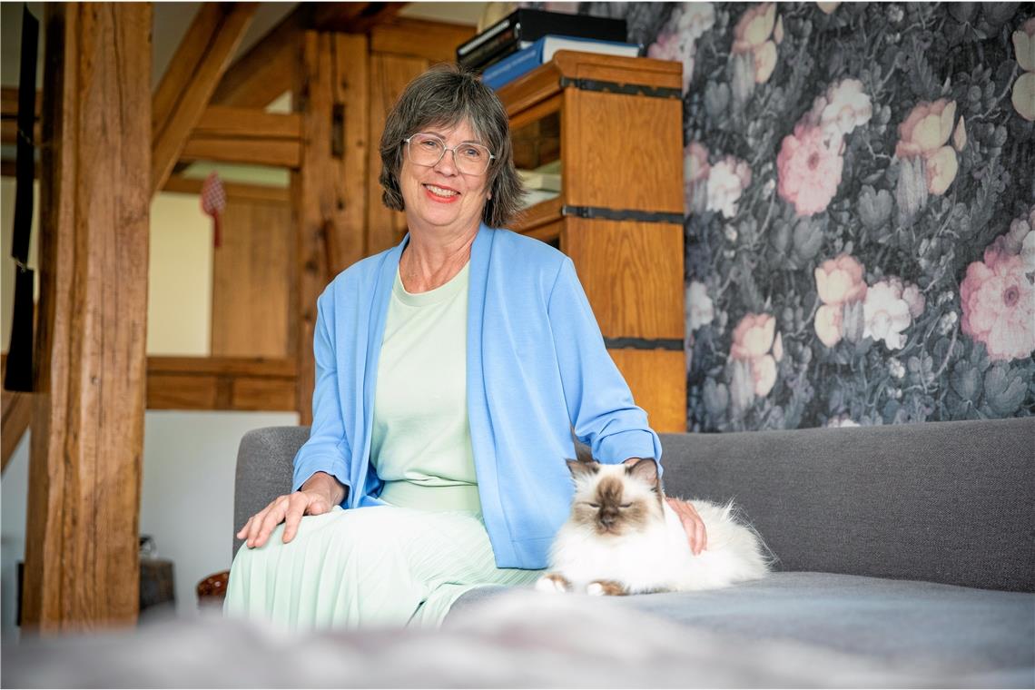 Kirsten Katz sitzt mit Kater Schoko auf dem Sofa in ihrer Wohnung in Haubersbronn. Foto: A. Becher