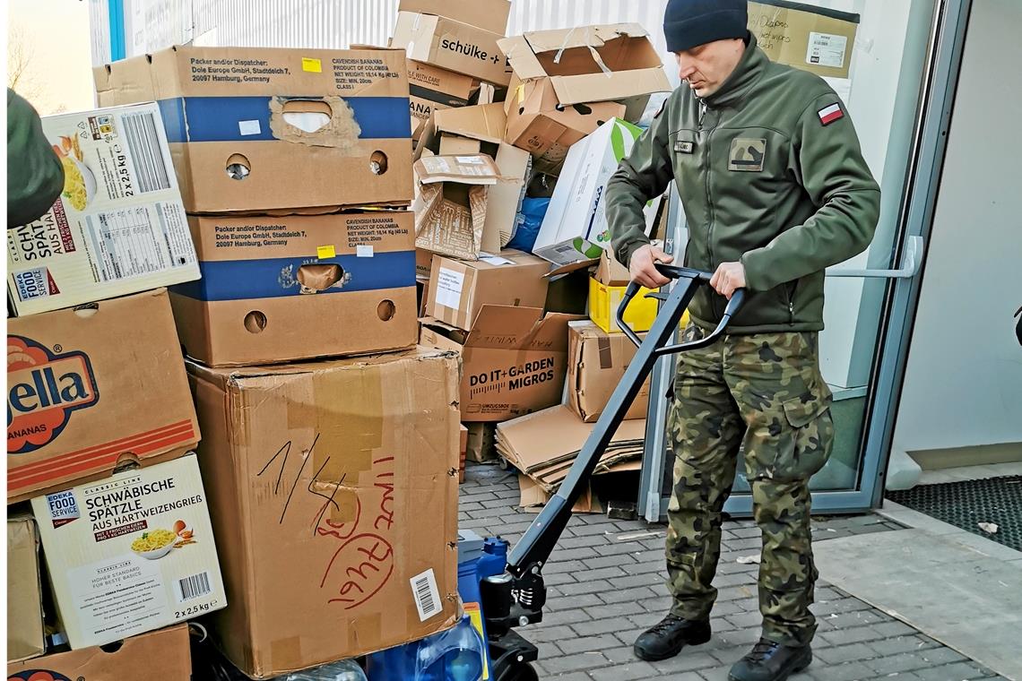 Kistenweise Sachspenden werden von polnischen Soldaten entgegengenommen.