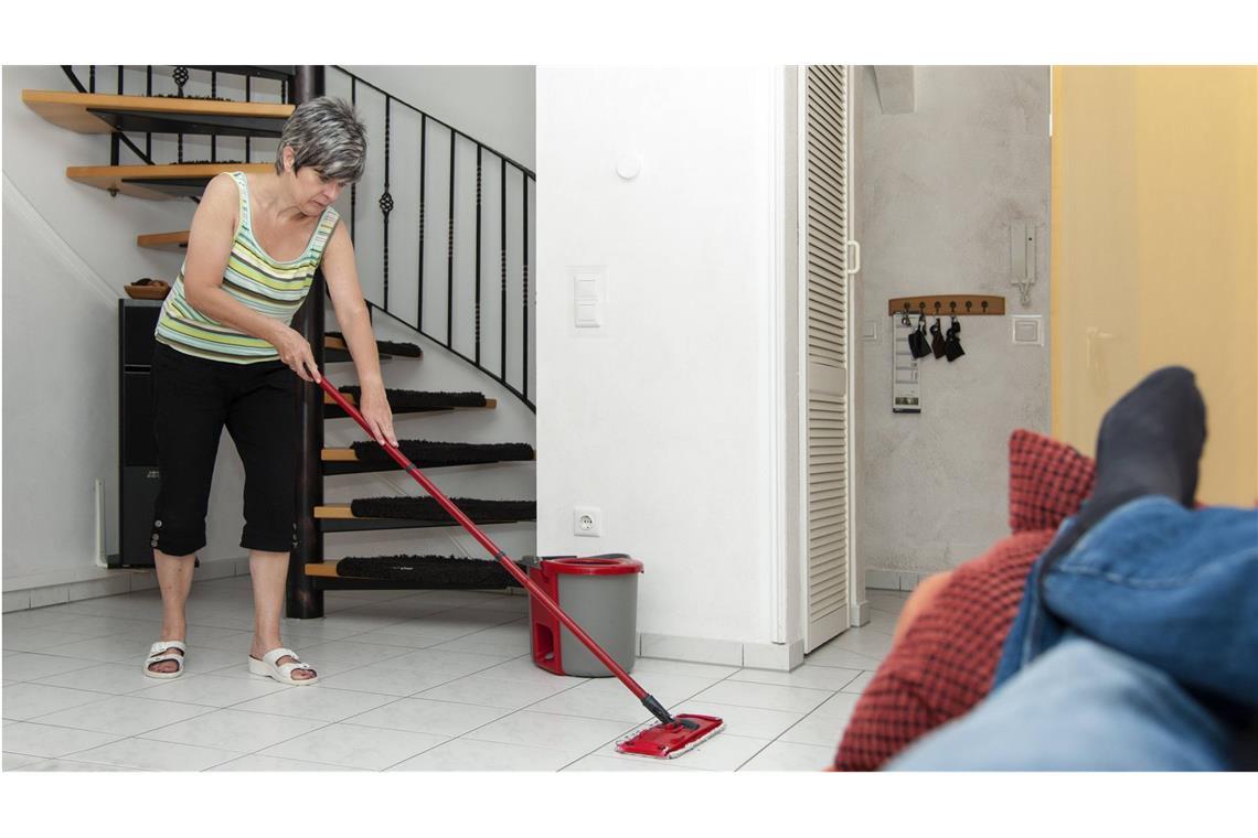 Nix als Kochen, Putzen, Waschen: Viele Frauen wollen sich trennen Klassisches Rollenbild: Während Mutter den Fußboden schrubbt, liegt Vater gemütlich auf dem Sofa.