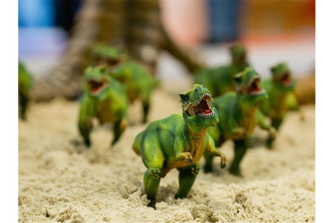 Kleine Figuren in Form eines T-Rex-Dinosauriers stehen in Nürnberg während der 67. Internationalen Spielwarenmesse am Stand des deutschen Herstellers Schleich. Foto: picture alliance / dpa