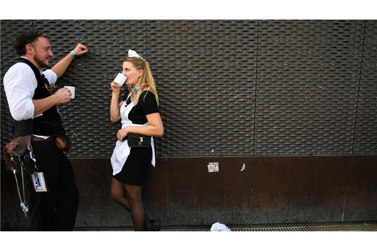 Kleine Pause für die Wiesn-Bewirtung: Bedienung Christina und Kellner Cedric  hinter dem Schottenhamel Festzelt auf dem Oktoberfest.