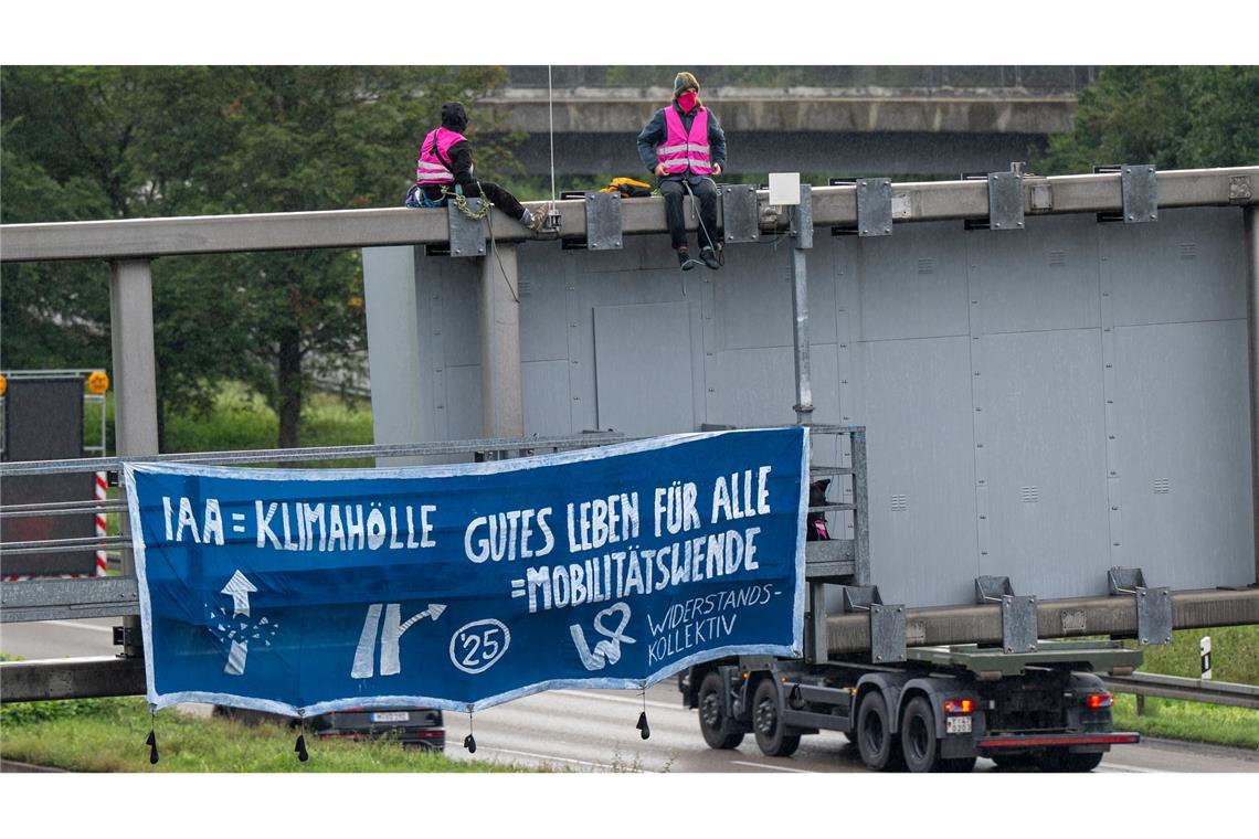 Klimaaktivisten protestieren auf der A9 in der Nähe der Allianz Arena mit einem Plakat gegen die IAA.