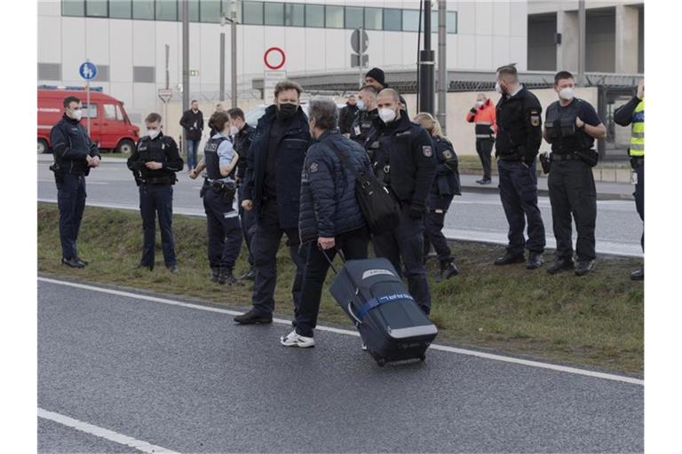 Klimaschutz-Aktivisten der Initiative "Aufstand der letzten Generation" blockieren eine Zufahrt zum Hauptstadt-Flughafen BER. Foto: Paul Zinken/dpa