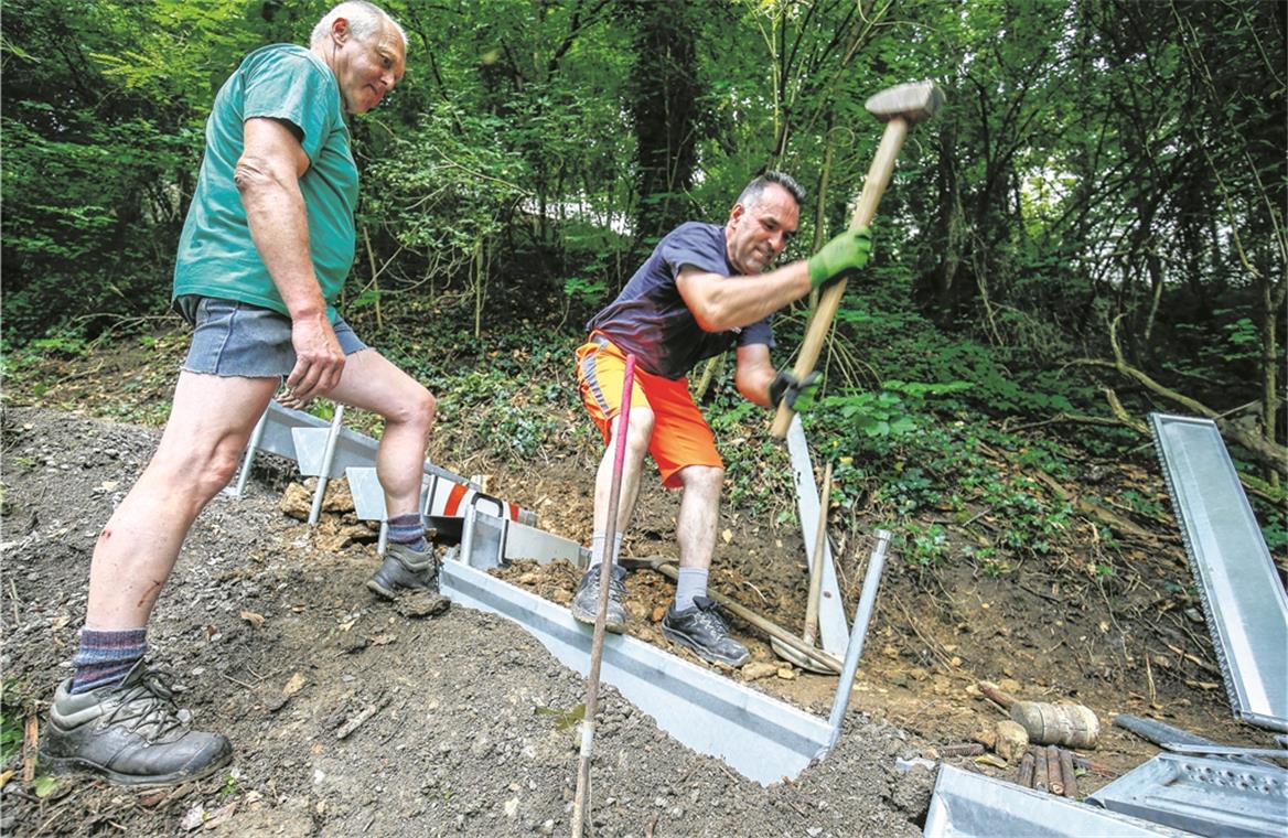Alpiner Wegebau mitten in der Stadt Knochenarbeit am Burgberg: Fadil Bajrami (rechts) und Joachim Walter vom städtischen Bauhof montieren die „Alpineisen“ im Gelände. Foto: A. Becher