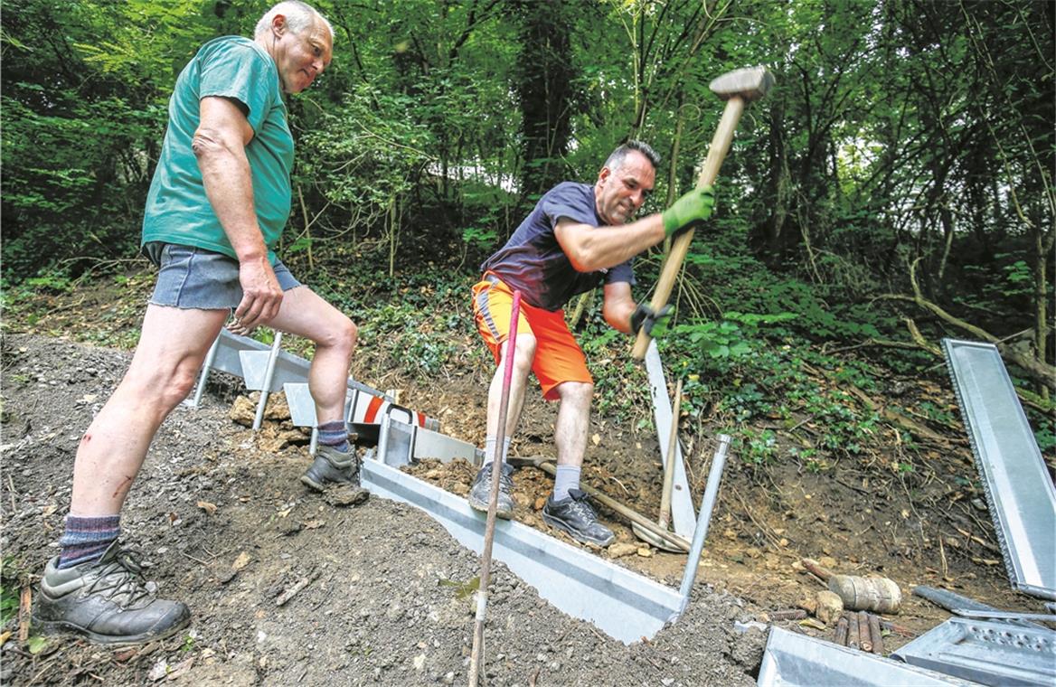 Knochenarbeit am Burgberg: Fadil Bajrami (rechts) und Joachim Walter vom städtischen Bauhof montieren die „Alpineisen“ im Gelände. Foto: A. Becher