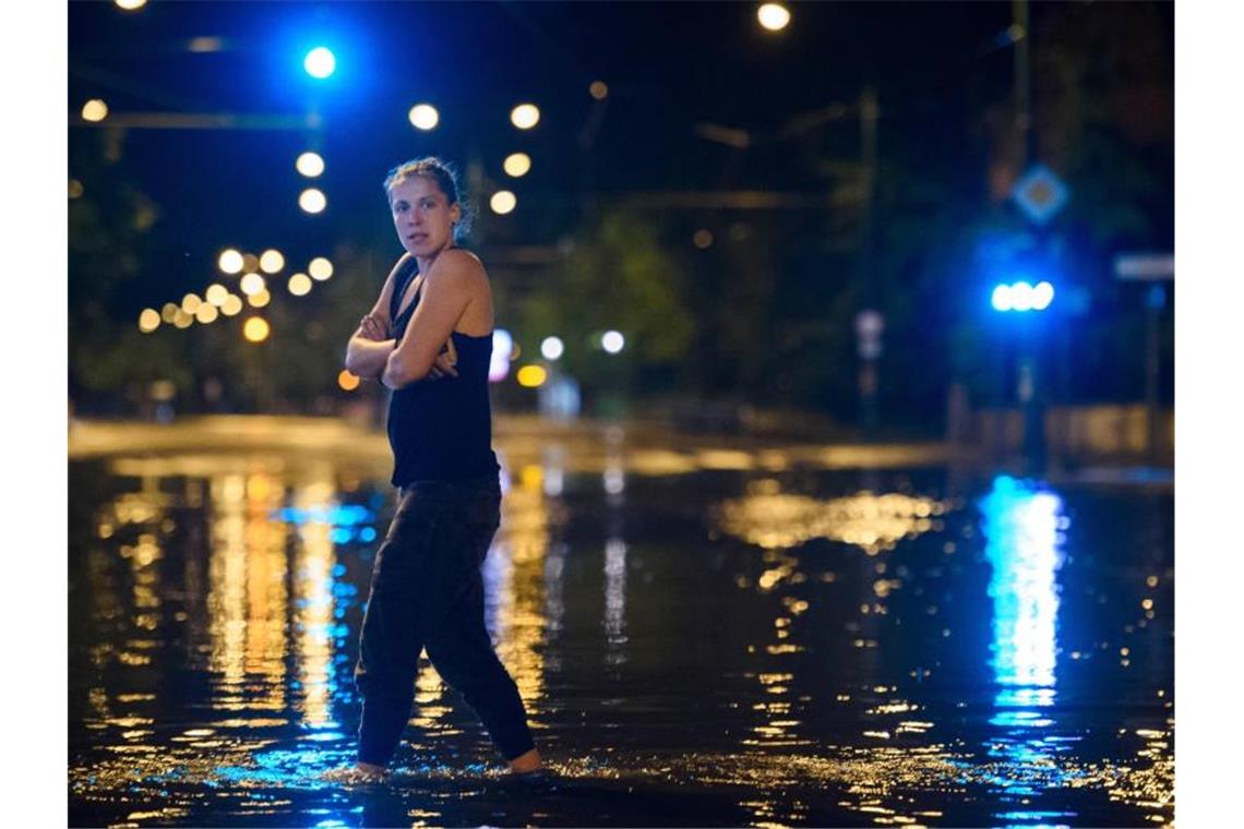 Bis zu 800 Blitze pro Minute - Starkregen flutet den Osten Knöcheltief im Wasser: Eine Passantin in Potsdam. Foto: Gregor Fischer