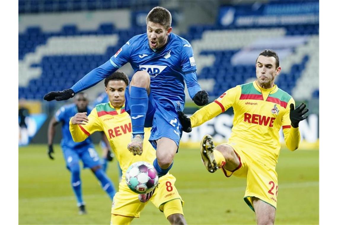 Kölns Ismail Jakobs (l-r), Hoffenheims Andrej Kramaric und Kölns Ellyes Skhiri kämpfen um den Ball. Foto: Uwe Anspach/dpa