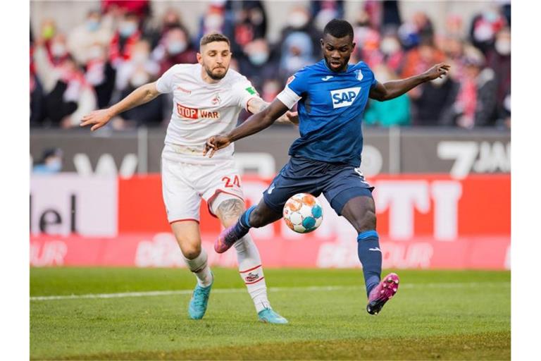 Kölns Jeff Chabot (l) und Hoffenheims Ihlas Bebou versuchen an den Ball zu kommen. Foto: Rolf Vennenbernd/dpa
