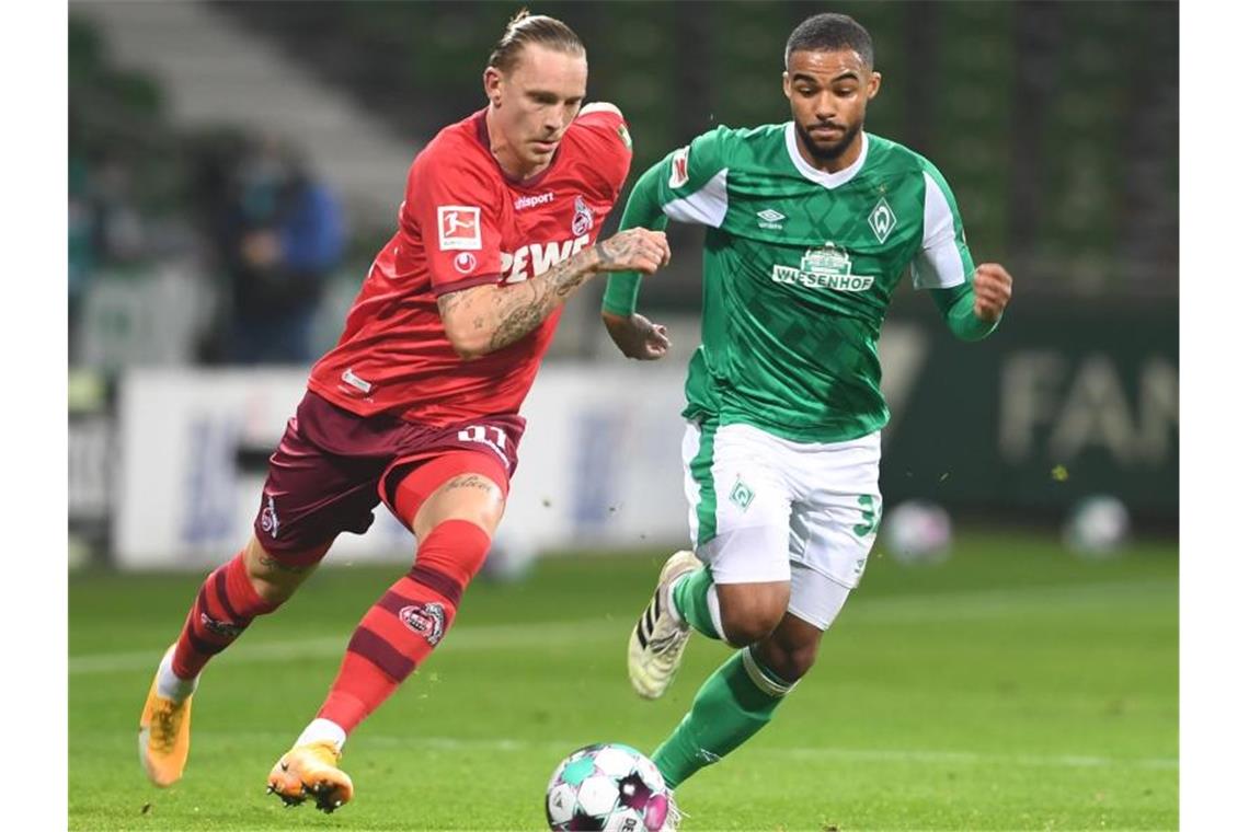 Kölns Marius Wolf (l) kämpft gegen Werders Jean-Manuel Mbom um den Ball. Foto: Carmen Jaspersen/dpa