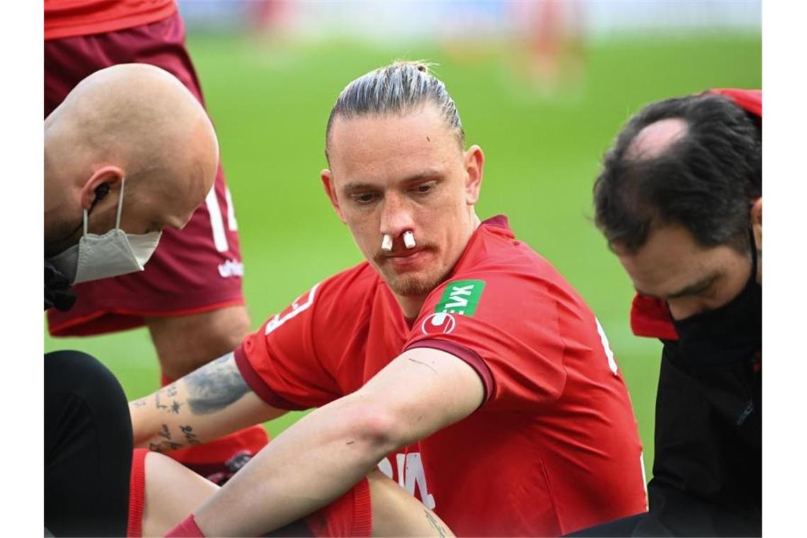 Joker-Tor nach 20 Sekunden: Kiel siegt in Köln Kölns Marius Wolf muss nach einem Zusammenprall behandelt werden. Foto: Ina Fassbender/AFP Pool/dpa