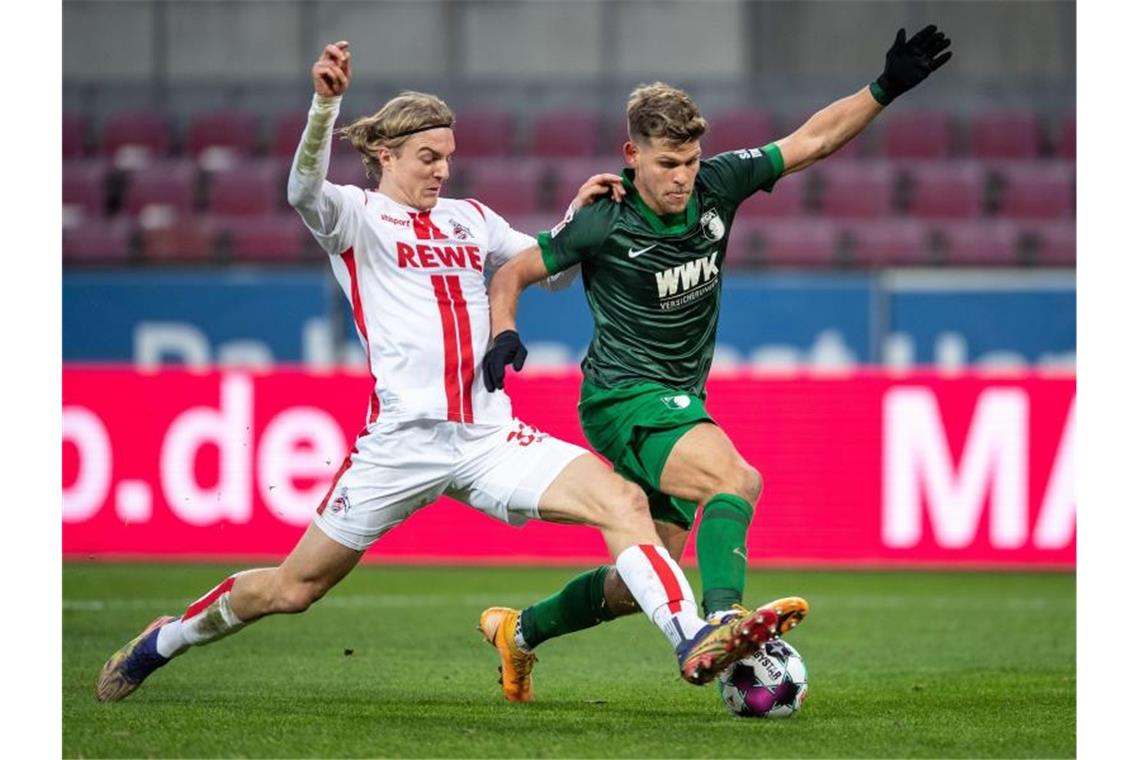 Schalke verliert bei Gross-Debüt - Leipzig an der Spitze Kölns Sebastian Bornauw (l) im Zweikampf mit Augsburgs Florian Niederlechner. Foto: Marius Becker/dpa