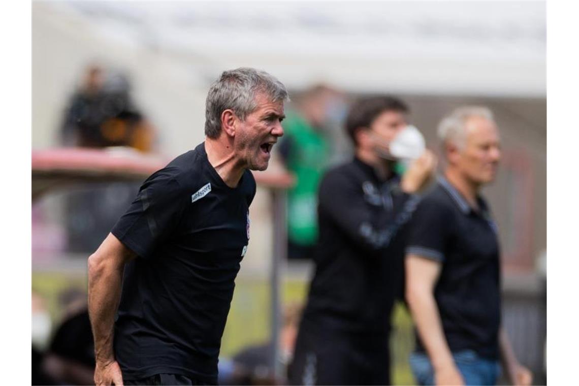 Köln-Coach Funkel: „Scheint nicht immer die Sonne“ Kölns Trainer Friedhelm Funkel versucht seine Spieler auf dem Platz zu erreichen - im Hintergrund steht Freiburgs Trainer Christian Streich. Foto: Rolf Vennenbernd/dpa