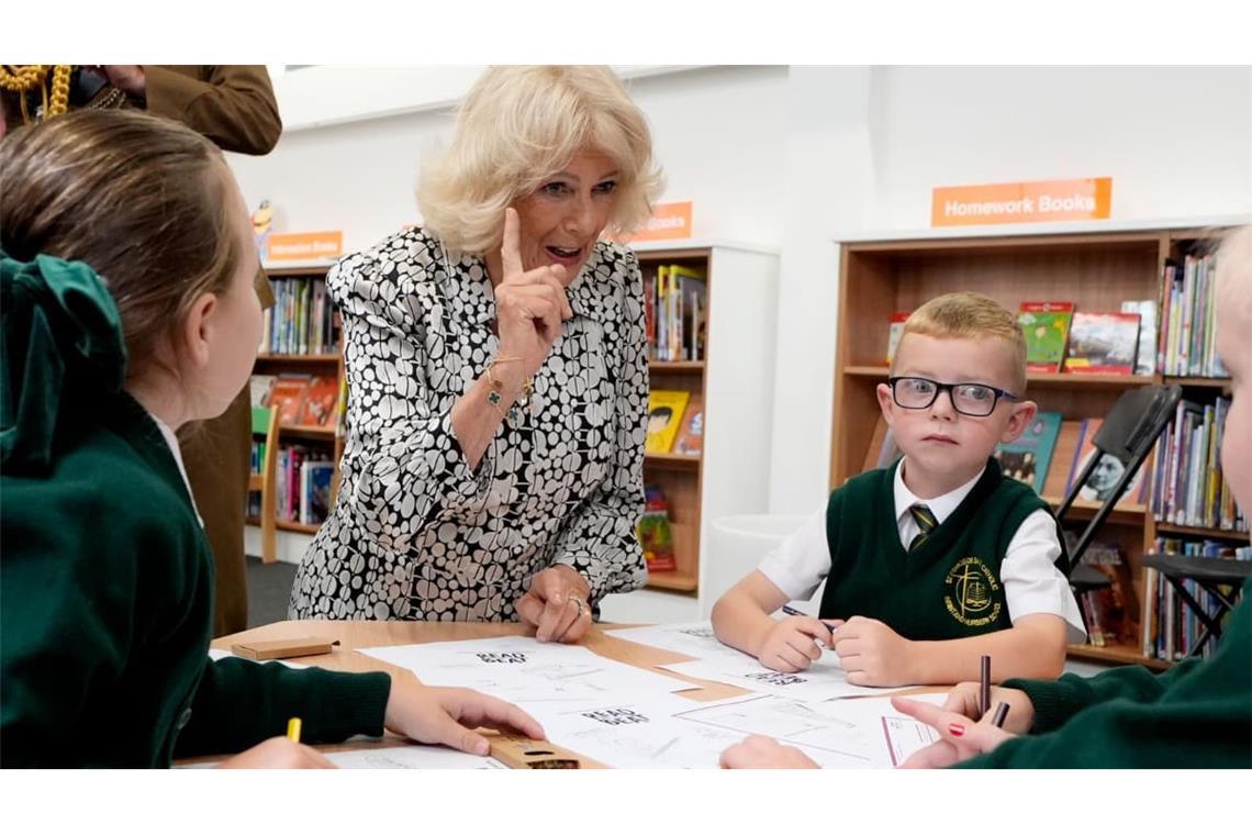 Königin Camilla spricht bei einem Besuch in der Spellow Hub Community Library in Liverpool mit örtlichen Schulkindern.