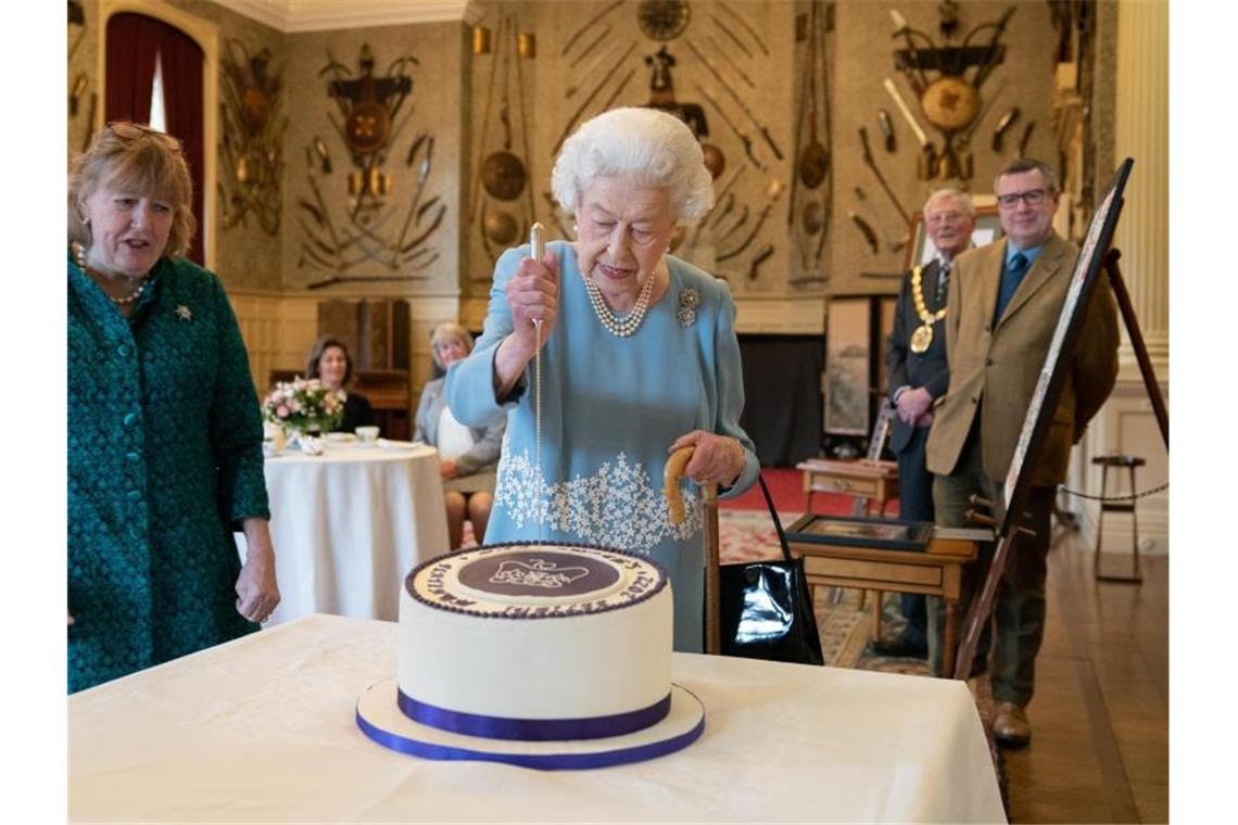 Queen empfängt kurz vor Thronjubiläum Bürger in Sandringham Königin Elizabeth II. schneidet die mitgebrachte Torte an. Foto: Joe Giddens/PA Wire/dpa