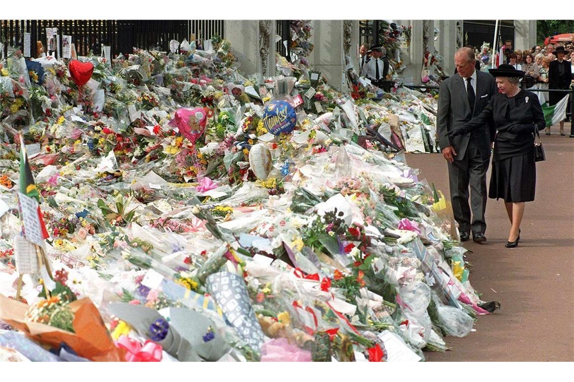 Königin Elizabeth II. und Prinz Philip gehen vor dem Buckingham-Palast an den unzähligen Blumen vorbei, die Trauernde nach Prinzessin Dianas Tod niedergelegt haben. Die zurückhaltende Reaktion des Königshauses wurde damals von vielen als gefühlskalt empfunden und beschädigte dessen Ansehen erheblich. Aufgrund der überwältigenden öffentlichen Trauer fand am 6. September 1997 entgegen dem üblichen Protokoll eine öffentliche Trauerfeier für Diana statt.