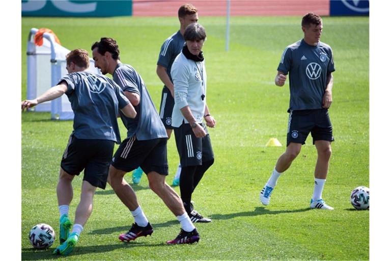 Kombination aus angespannter Arbeit und lockeren Übungen: Bundestrainer Joachim Löw (M) leitet das Training seiner Mannschaft. Foto: Federico Gambarini/dpa