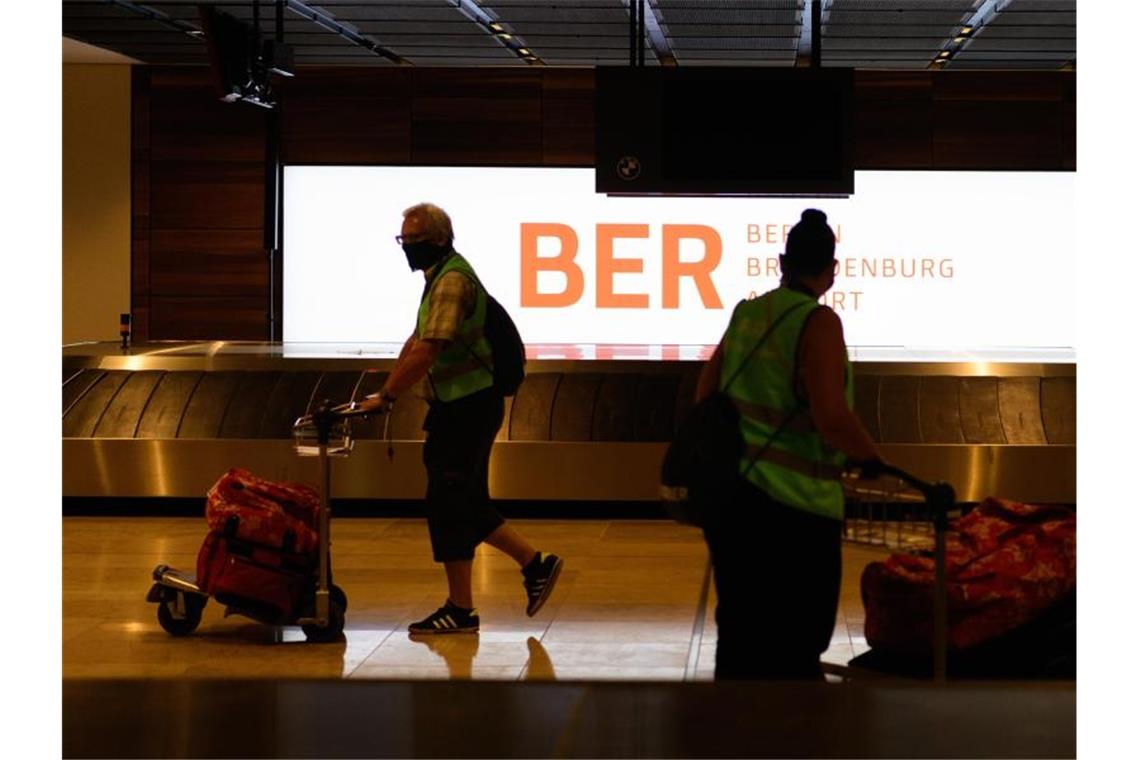Probebetrieb im neuen Hauptstadtflughafen BER beendet Komparsen in Warnwesten gehen beim Probelauf im Terminal 1 des Hauptstadtflughafens Berlin-Brandenburg (BER) mit ihren Koffern zum Check in. Foto: Soeren Stache/dpa-Zentralbild/dpa