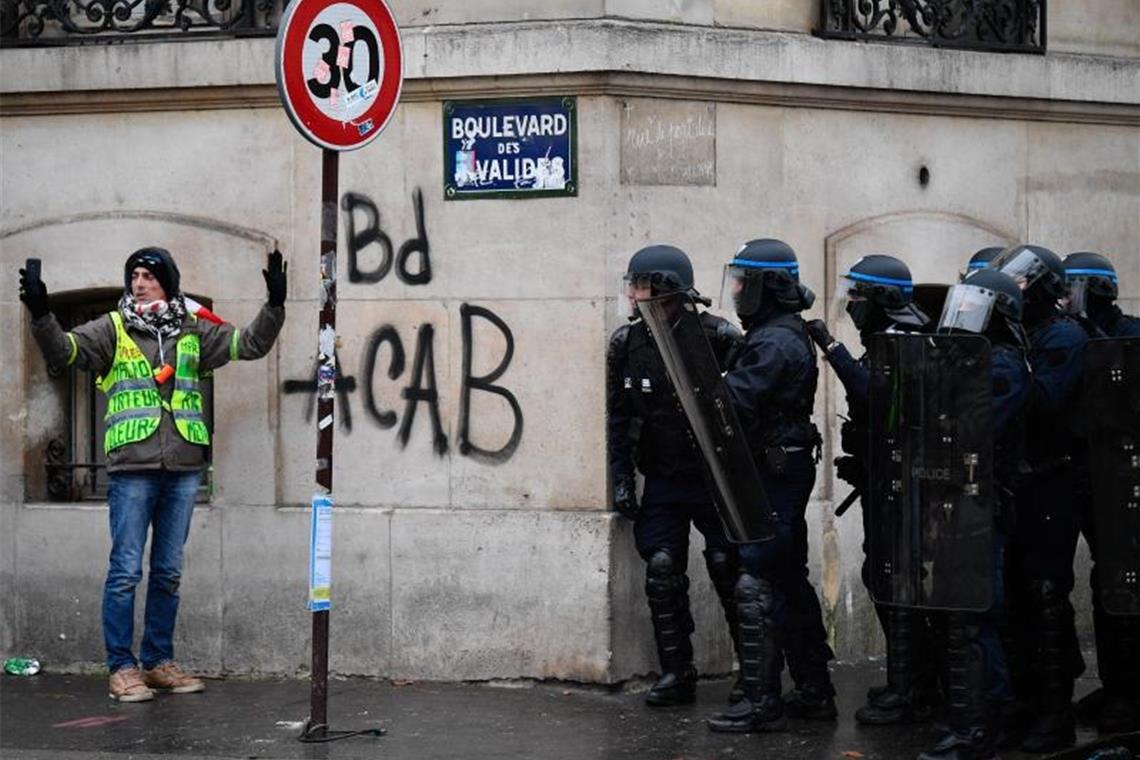 Konfrontation in Paris: Ein Teilnehmer der „Gelbwesten“-Proteste macht direkt vor einer Gruppe Polizisten ein Selfie. Foto: Julien Mattiale Pictorium/Le Pictorium Agency via ZUMA/dpa
