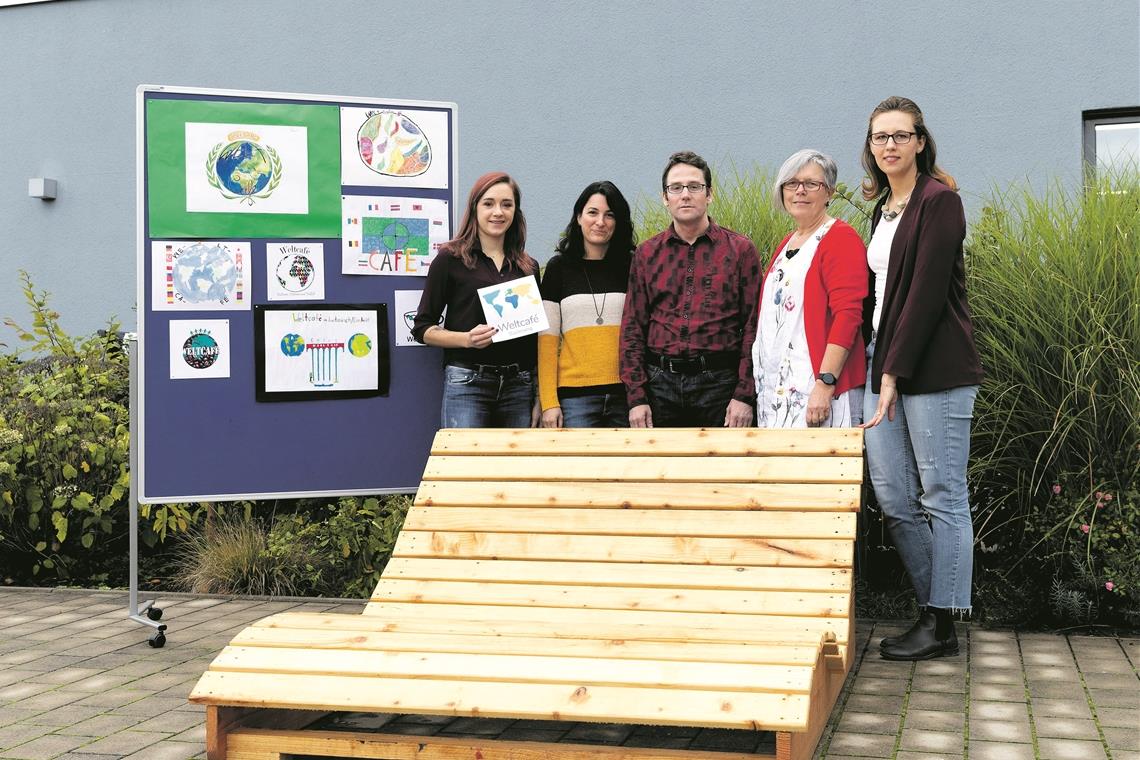 Kooperieren im Weltcafé (von links): Tatjana Riekert mit dem Siegermotiv aus dem Logowettbewerb, Melanie Rautscher, Marc Hinderer, Marion Scheffler-Duncker und Sandra Amofah. Die XXL-Liege ist im Sommer bei einem Weltcafé-Projekt im Backnanger Freibad entstanden. Foto: J. Fiedler