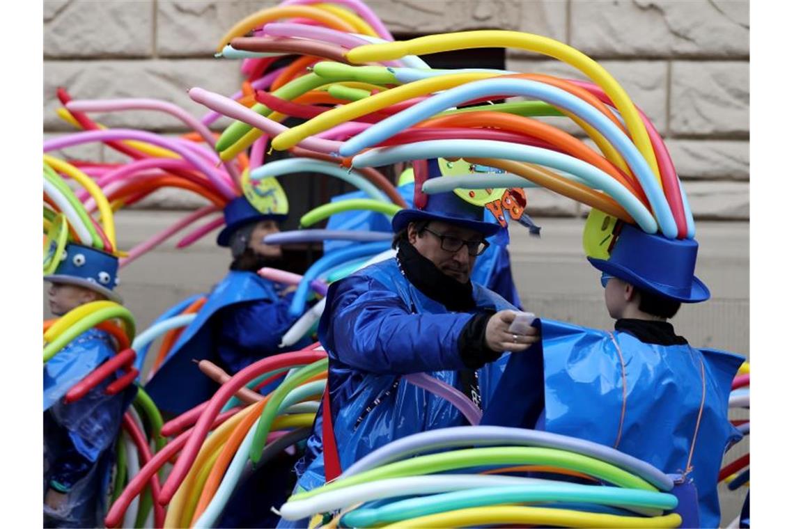 Kostüme von Karnevalisten wiegen im Wind. Foto: Oliver Berg/dpa