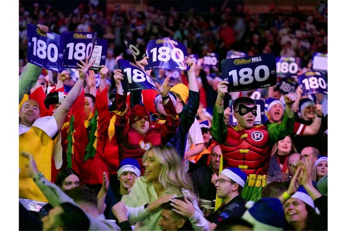 Kostümierte Fans feiern einen geworfenen 180er. Foto: John Walton/PA Wire/dpa