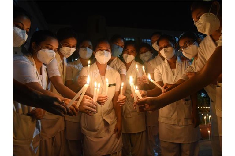 Krankenschwestern erinnern mit Kerzen an die verstorbenen Ärzte, die ihr Leben durch Corona verloren haben. Foto: Dasarath Deka/ZUMA Wire/dpa