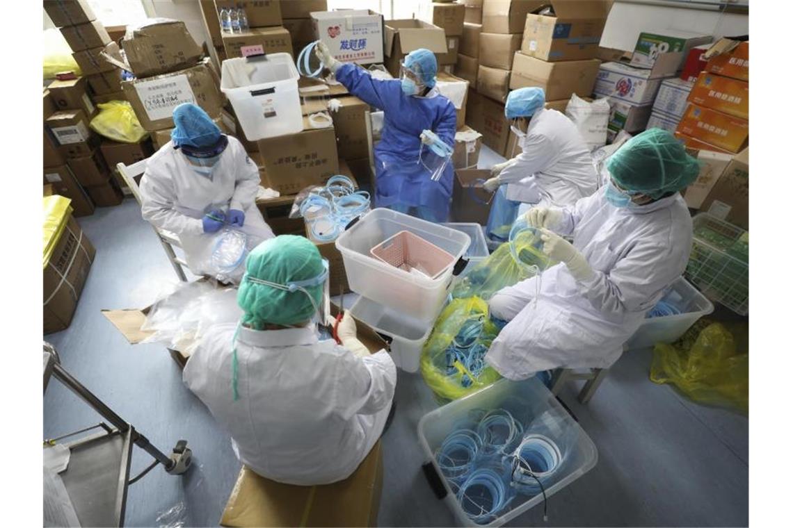 Coronavirus: Weitere Neu-Infektionen in China und Südkorea Krankenschwestern montieren Gesichtsmasken für Infizierte. Foto: Uncredited/CHINATOPIX/AP/dpa