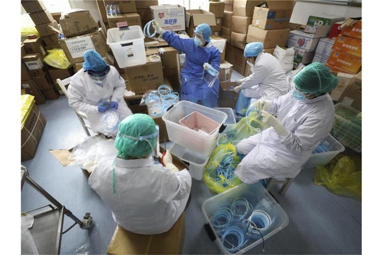 Krankenschwestern montieren Gesichtsmasken für Infizierte. Foto: Uncredited/CHINATOPIX/AP/dpa
