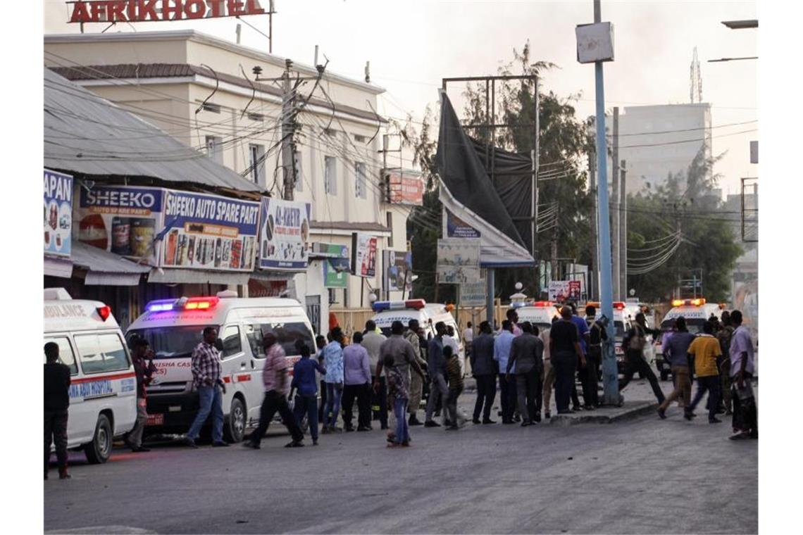 Anschlag von Islamistenmiliz auf Hotel in Mogadischu beendet Krankenwagen, Sicherheitskräfte und Passanten versammeln sich auf der Straße vor dem Afrik Hotel. Foto: Farah Abdi Warsameh/AP/dpa