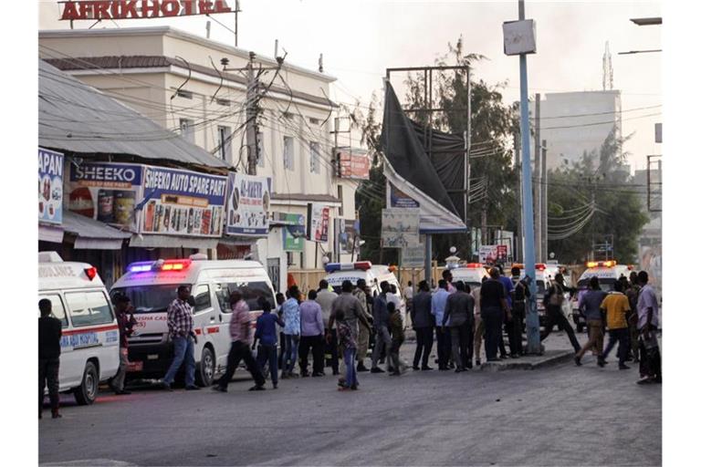 Krankenwagen, Sicherheitskräfte und Passanten versammeln sich auf der Straße vor dem Afrik Hotel. Foto: Farah Abdi Warsameh/AP/dpa