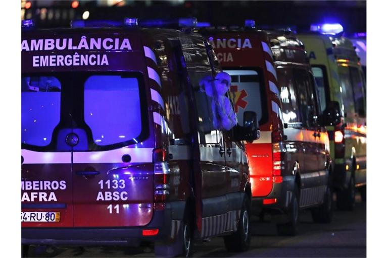 Krankenwagen warten vor einem Krankenhaus in Lissabon darauf, COVID-19-Patienten an Sanitäter zu übergeben. Foto: Armando Franca/AP/dpa