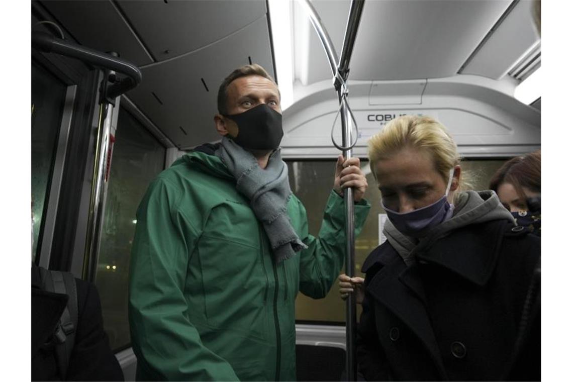 Kremlgegner Alexej Nawalny (M) und seine Ehefrau Julia (r) stehen am Flughafen Moskau-Scheremetjewo in einem Bus. Foto: Mstyslav Chernov/AP/dpa