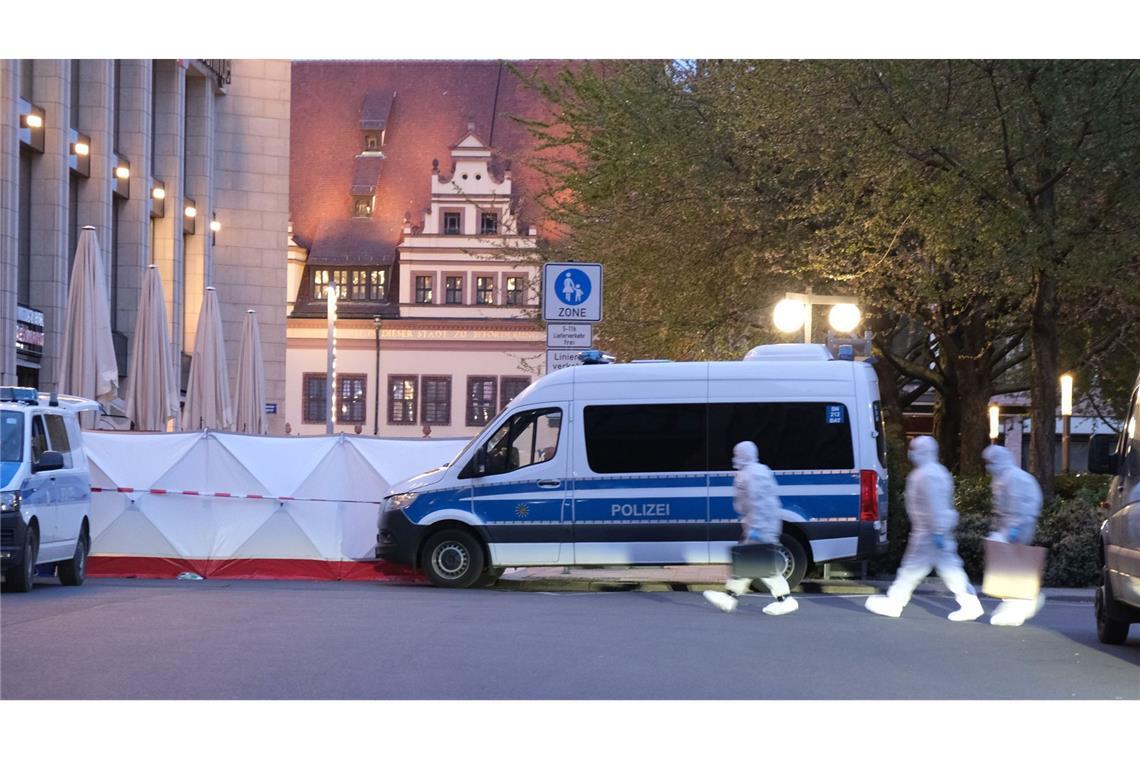 Kriminaltechniker gehen zum Tatfahrzeug. In Leipzig ist ein Auto in mehrere Menschen gefahren.