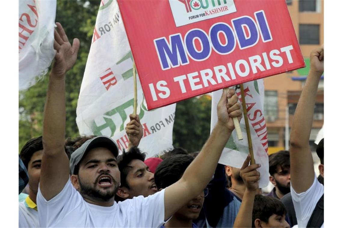 Pakistan schränkt diplomatische Beziehungen zu Indien ein Kritik an Indiens Premierminister: Ein pakistanischer Demonstrant hält bei einer Kundgebung ein Schild in die Höhe. Foto: K.M. Chaudary/AP