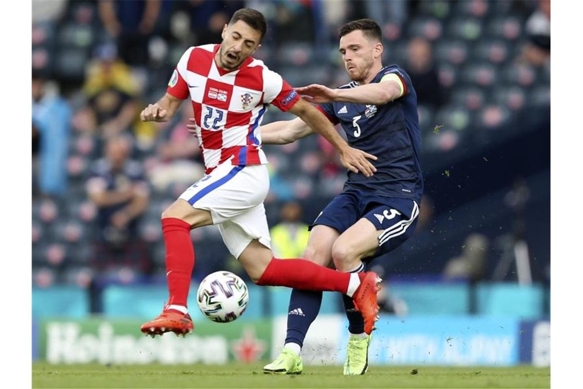 Kroatiens Josip Juranovic (l) und Schottlands Andrew Robertson kämpfen um den Ball. Foto: Robert Perry/EPA Pool/AP/dpa