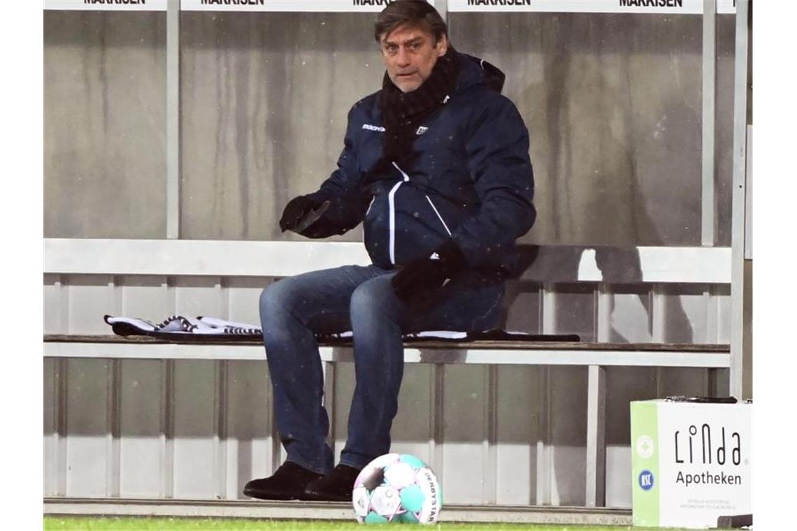 KSC-Sportchef Oliver Kreuzer sitzt auf der Bank. Foto: Uli Deck/dpa/archivbild