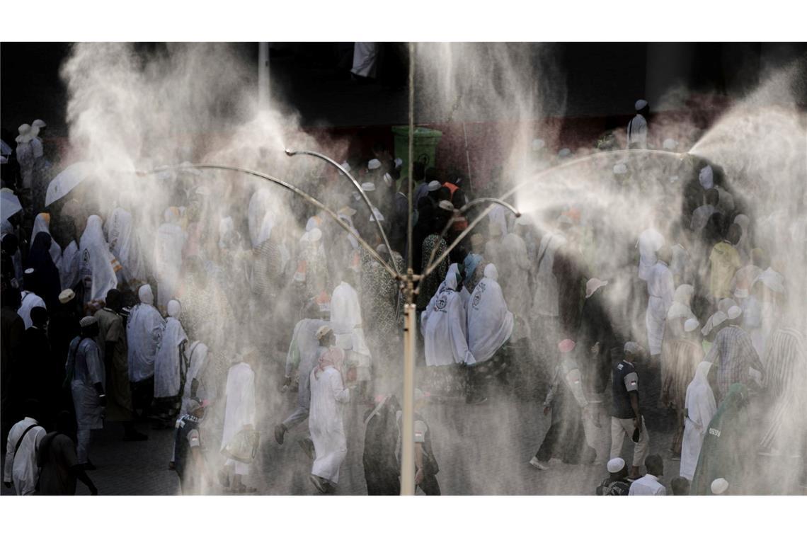 Kühlventilatoren besprühen muslimische Pilger mit Wasser, während sie zur symbolischen Steinigung des Teufels, dem letzten Ritus der jährlichen Hadsch, in Mina in der Nähe der heiligen Stadt Mekka Steine an Säulen werfen.