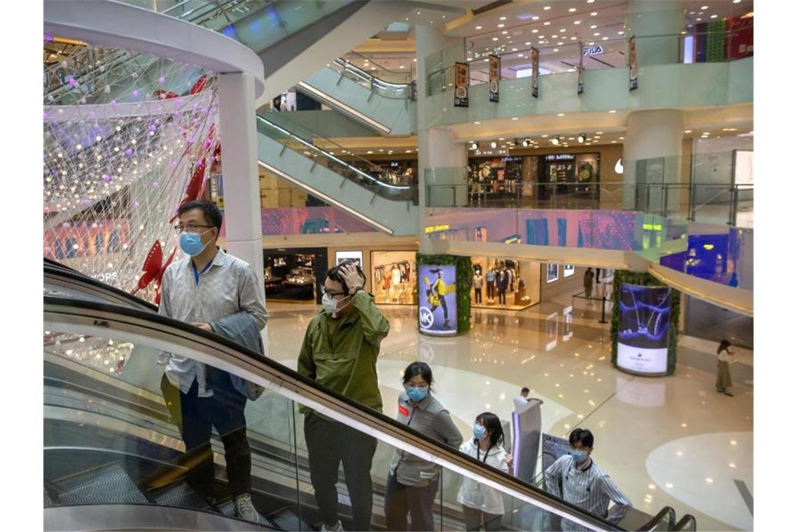 Kunden in einem Einkaufszentrum in Peking. Auch Chinas Unternehmen leiden schwer unter der Corona-Krise. Foto: Mark Schiefelbein/AP/dpa