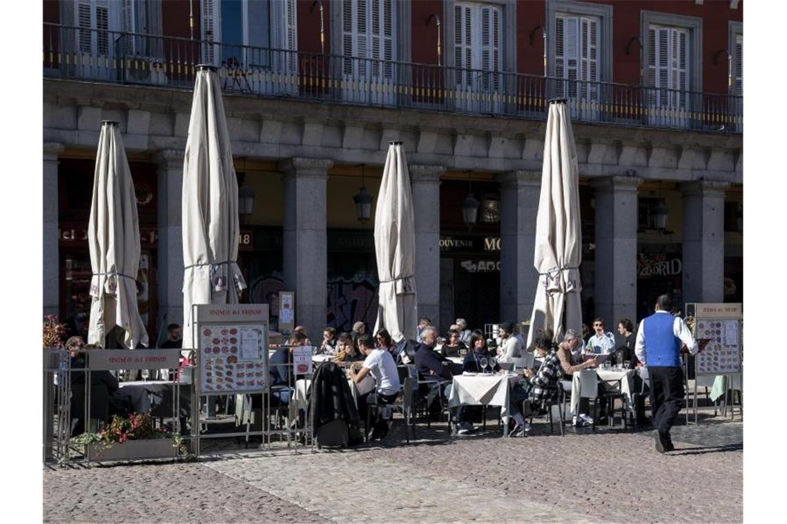 Kunden sitzen auf einer Terrasse in Madrid. In Spanien ist die Corona-Lage derzeit entspannt. Foto: A. Pérez Meca/EUROPA PRESS/dpa